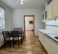 NA PREDAJ 3 a pól izbový byt Nitra Klokočina - Kuchyňa v 3-izbovom byte s jedálenským stolom a podlahou s dreveným dekorom.
