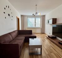 NA PREDAJ 3 a pól izbový byt Nitra Klokočina - Obývacia izba s hnedým gaučom a podlahou s dreveným dekorom, 3-izbový byt.