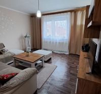 NA PREDAJ 6 izbový rodinný dom v obci Hrušovany  - Obývacia izba v rodinnom dome s podlahou s dreveným dekorom a pohodlnou pohovkou.