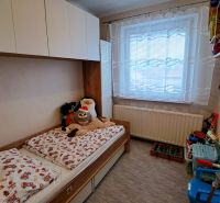 NA PREDAJ 6 izbový rodinný dom v obci Hrušovany  - Detská izba so sivým kobercom, posteľou a hračkami v Rodinnom dome.