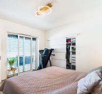NA PREDAJ moderná 4 izb novostavba RD v Nitre časť Lužianky - Spálňa s bežeckým pásom, vstavanou skriňou a podlahou s dreveným dekorom v rodinnom dome.