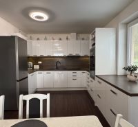 NA PREDAJ Rodinný dom v krásnom prostredí obce Štitáre NITRA - Kuchyňa v rodinnom dome s bielymi skrinkami a podlahou s dreveným dekorom.
