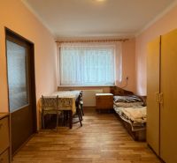 NA PREDAJ Rodinný dom - Šurany - Nitriansky Hrádok, EXKLUZÍVNE - Izba v rodinnom dome so stolom, stoličkami, posteľou a skriňou.