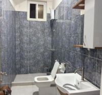 2-IZBOVÝ CONDO APARTMÁN PRI PLÁŽI, MBWENI, ZANZIBAR - Kúpeľňa v 2-izbovom byte s keramickými obkladmi a bielym sanitárnym zariadením.