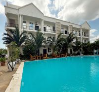 2-IZBOVÝ CONDO APARTMÁN PRI PLÁŽI, MBWENI, ZANZIBAR - Budova pri bazéne a palmách v časti Mbweni v Zanzibare.