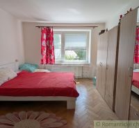 Na predaj 2- izbový byt s malou záhradkou v Medzilaborciach - 51 m2. - Spálňa v 2-izbovom byte s posteľou, šatníkom a podlahou s dreveným dekorom.
