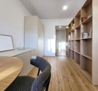 Na predaj úplne nový 1i byt od architekta v tichej časti Dúbravky - 1-izbový byt s podlahou s dreveným dekorom, skrinka a poličky na knihy.