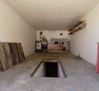 Nadštandardne vybavená garáž s pivnicou a studňou v Štúrove - Garáže s montážnou jamou a úložnými priestormi s regálmi a drevenými plochami.