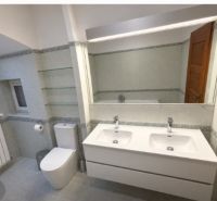 NÍZKOENERGETICKÝ RODINNÝ DOM VO VALČI  – TICHÉ PROSTREDIE - Kúpeľňa v rodinnom dome s dvojitým umývadlom, WC a zrkadlom.