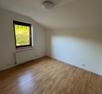 NÍZKOENERGETICKÝ RODINNÝ DOM VO VALČI  – TICHÉ PROSTREDIE - Izba v rodinnom dome s podlahou s dreveným dekorom a radiátorom pod oknom.
