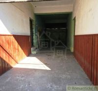 Multifunkčná budova v srdci Modrého Kameňa v okrese Veľký Krtíš - Garáž v obchodných priestoroch Modrého Kameňa so steny s dreveným obkladom.