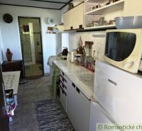 Chata na celoročné bývanie v Modrom Kameni, okres Veľký Krtíš - Kuchynka v chate s bielymi skriňami a spotrebičmi, vedľa kúpeľňa.