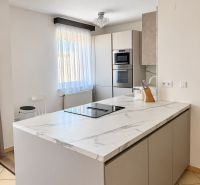 PRENÁJOM - 3-izbový zariadený byt s balkónom a garážou - Šustekova - Kuchyňa v 3-izbovom byte s ostrovčekom a zabudovanými spotrebičmi, podlaha s dreveným dekorom.