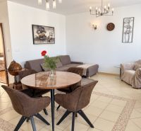 PRENÁJOM - 3-izbový zariadený byt s balkónom a garážou - Šustekova - Obývacia izba v 3-izbovom byte s elegantným osvetlením a jedálenským stolom.