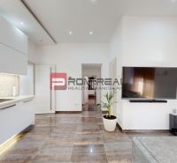 6i DVOJGENERAČNÝ DOM PO REKONŠTRUKCII S VEĽKÝM POZEMKOM A SMARTHOME –  - Interiér rodinného domu s televízorom, bielym nábytkom a podlahou s dreveným dekorom.