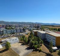 Na predaj 3 izbový byt Žiar nad Hronom, 75 m2 - Výhľad na sídliská a budovy v ulici SNP v Žiari nad Hronom s horami v pozadí.