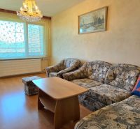 Na predaj 3 izbový byt Žiar nad Hronom, 75 m2 - Obývacia izba so sedačkou, lustrami a podlahou s dreveným dekorom v 3-izbovom byte.