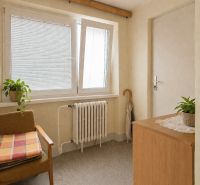 RODINNÝ DOM S VÝNIMOČNOU ZÁHRADOU, 1 141 M², BANSKÁ BYSTRICA  - Izba v rodinnom dome s kreslom, skrinkou, rastlinami a radiátorom pod oknom.