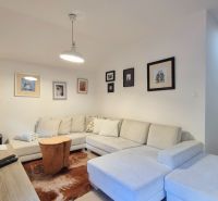3 - IZBOVÝ APARTMÁN POD CHOPKOM, 52M2 - Obývacia izba s pohodlnou sedacou súpravou, obrázkami na stene a lampou v Rekreačnom apartmáne.