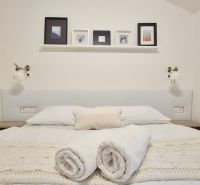 3 - IZBOVÝ APARTMÁN POD CHOPKOM, 52M2 - Svetlá spálňa v Rekreačnom apartmáne s pohodlnou posteľou a dekoráciami na stene.