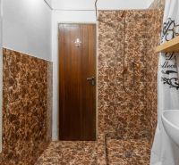 I VILA REIM – Exkluzívna investičná príležitosť  - Kúpeľňa na Chate s mramorovým obkladom a bielym radiátorom.