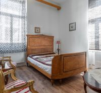 I VILA REIM – Exkluzívna investičná príležitosť  - Spálňa v chate s dreveným nábytkom, vzorované závesy a podlaha s dreveným dekorom.