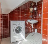 I VILA REIM – Exkluzívna investičná príležitosť  - Červenými obkladačkami obložená kúpeľňa na chate s práčkou a umývadlom.