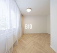 NOVO ZREKONŠTRUOVANÝ 4-IZBOVÝ BYT V TICHOM PROSTREDÍ - 78 m² - NOVÉ ME - Izba v 4-izbovom byte s bielymi stenami a podlahou s dreveným dekorom.
