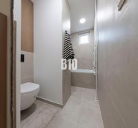 NOVO ZREKONŠTRUOVANÝ 4-IZBOVÝ BYT V TICHOM PROSTREDÍ - 78 m² - NOVÉ ME - Kúpeľňa v 4-izbovom byte s vaňou, toaletou a dlažbou v neutrálnych tónoch.