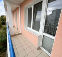 I Na predaj 2-i byt s veľkou loggiou v Ružinove – Trávniky - Balkón s dlažbou v 2-izbovom byte, výhľad na zeleň a okolitú architektúru.