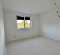NA PREDAJ - Rodinný dom v JARKU, 4 izb. bungalov - Prázdna miestnosť s bielymi stenami a podlahou, okno s výhľadom do záhrady.