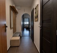 3- izbový byt na  Viglašskej ulici  - Chodba 3-izbového bytu s dlaždicovou podlahou, vešiakmi a lavicou.