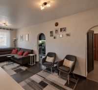 3- izbový byt na  Viglašskej ulici  - Obývačka v 3-izbovom byte s pohovkou, kreslami a podlahou s dreveným dekorom.
