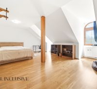 SÚKROMNÉ SÍDLO NA KONCI KÚPEĽNÉHO PARKU | 4 454 m² | TRENČ. TEPLICE - Podkrovná spálňa s posteľou, podlahou s dreveným dekorom a oknom v rodinnom dome.