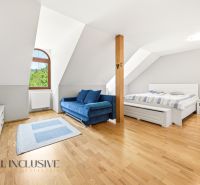 SÚKROMNÉ SÍDLO NA KONCI KÚPEĽNÉHO PARKU | 4 454 m² | TRENČ. TEPLICE - Svetlá spálňa s modrou pohovkou, posteľou a podlahou s dreveným dekorom v rodinnom dome.