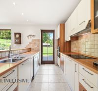 SÚKROMNÉ SÍDLO NA KONCI KÚPEĽNÉHO PARKU | 4 454 m² | TRENČ. TEPLICE - Kuchyňa v rodinnom dome s dlažbou, dreveným dekorom a výhľadom do záhrady.