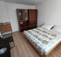 Na prenájom - Zariadený 3 izbový byt na Lipovci so záhradou - Spálňa v 3-izbovom byte s podlahou s dreveným dekorom a jednoduchým zariadením.