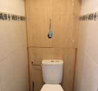PRENÁJOM- 2-izbového bytu v centre mesta Šaľa – pešia zóna  - Toaleta s keramickými obkladmi, modrými podlahovými dlaždicami a úložným priestorom.