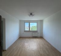 PRENÁJOM- 2-izbového bytu v centre mesta Šaľa – pešia zóna  - Obývacia izba v 2-izbovom byte s podlahou s dreveným dekorom a veľkým oknom.