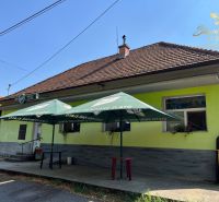 Obchodný priestor s ubytovacím zariadením - Exteriér gastronomických priestorov v Kozárovciach so slnečníkmi nad vchodom.