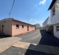 Obchodný priestor s ubytovacím zariadením - Exteriér gastro priestorov v Kozárovciach s dláždeným a štrkovým povrchom.