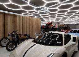 Motorky a športové vozidlá v obchodných priestoroch s moderným osvetlením.