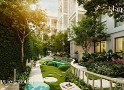 Exteriér výstavby bytov v Phukete s detským ihriskom obklopeným zeleňou.