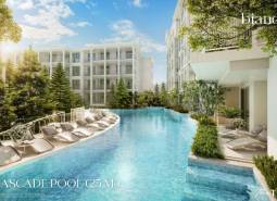 Bazén s ležadlami obklopený budovami vo výstavbe bytov v Phukete.