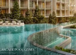 Bazén s kaskádami pri výstavbe bytov v Phukete s ležadlami a zeleňou.