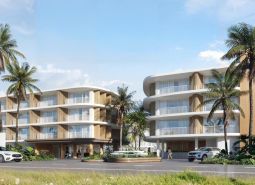 Výstavba bytov v Surat Thani s palmovými stromami a modernou architektúrou.