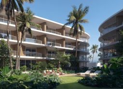 Výstavba bytov v Surat Thani: apartmánové budovy s palmami a zeleňou na pozadí.