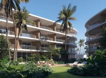 Výstavba bytov v Surat Thani: apartmánové budovy s palmami a zeleňou na pozadí.