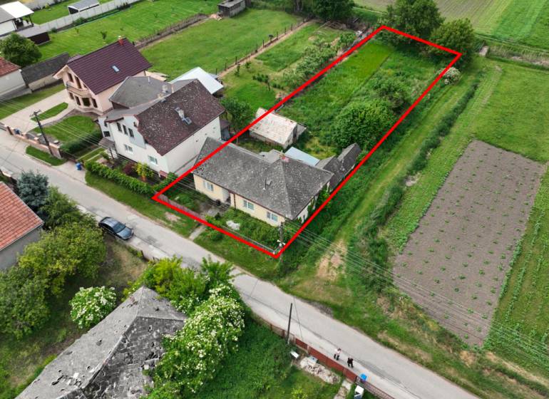 Dulovce - RODINNÝ DOM so 700 m2 POZEMKOM - Letecký pohľad na rodinný dom v Dulovciach s veľkou záhradou a okolím.