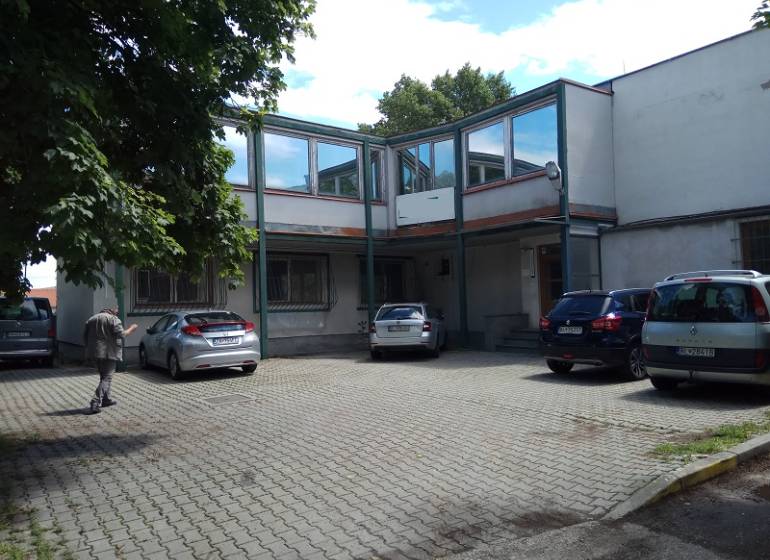 Administratívno-skladová budova Bratislava - Trnávka - Dvor s parkujúcimi autami pri výrobných priestoroch na Beckovskej ulici v Bratislave - Ružinove.